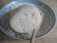 用小勺舀一匙洗净的糯米，平铺放在莲藕的切面上，用筷子把糯米拨进藕空中，一边填，一边用筷子捅结实一点